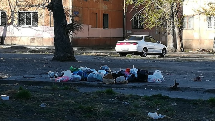 Во дворе на правом берегу перенесли мусорку. Жители возмущены и валят отходы на старое место