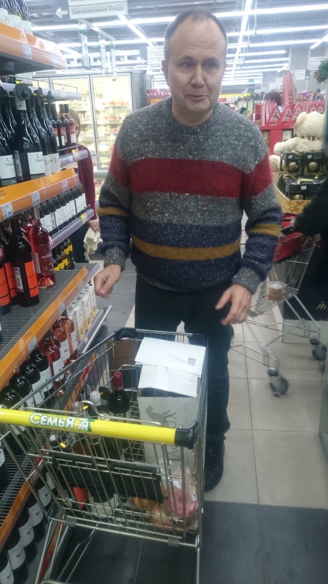 Олег Чиркунов расставляет бутылки на полки проекта «Правильное вино»