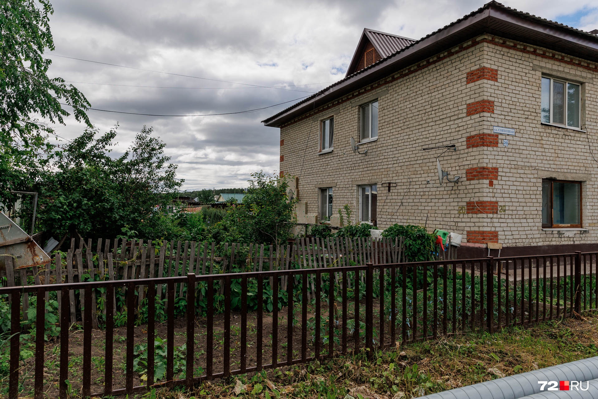 Рядом с двухэтажными домами люди разбивают огородики Рядом с двухэтажными домами люди разбивают огородики
