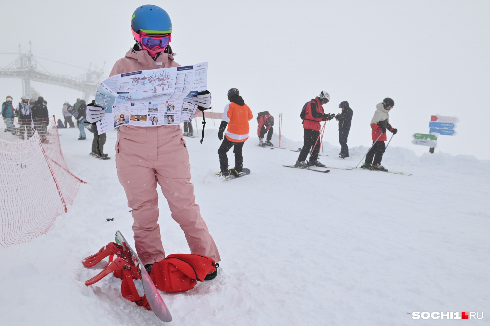 Лыжница изучает карту горнолыжного курорта
