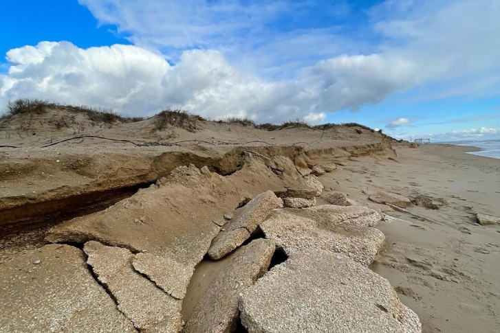 Волны зашли вглубь пляжа и разбили слои ракушки, лежавшие под песком