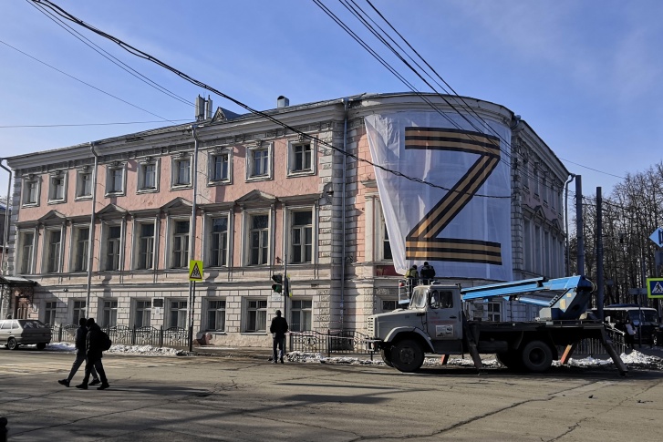 Плакат с символом, обозначающим поддержку военной спецоперации на Украине, занял внушительную часть фасада здания