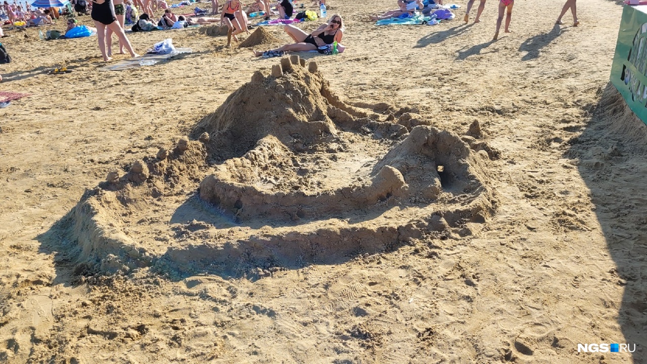 Дети на пляже строят замки из песка
