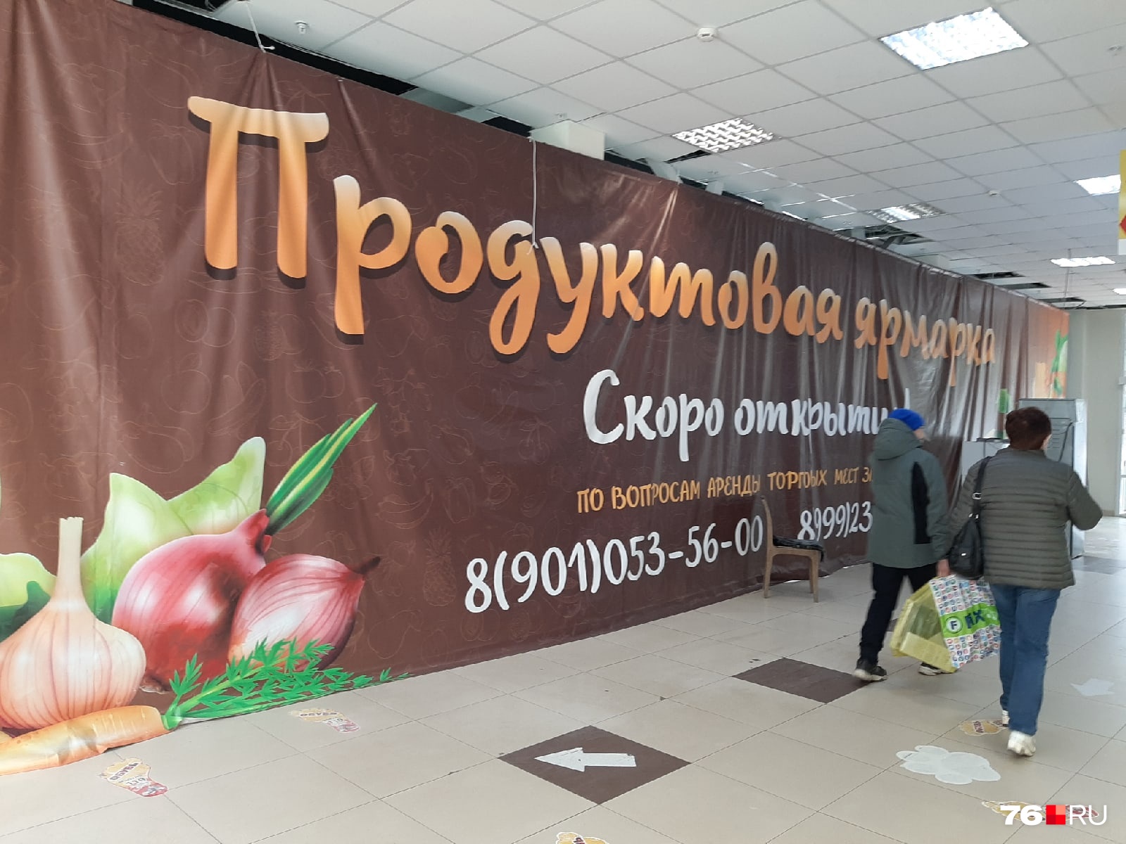 Работы здесь не закончены. Площадь, где идет ремонт, огородили огромным баннером. За ним — коробки, доски, рабочие Работы здесь не закончены. Площадь, где идет ремонт, огородили огромным баннером. За ним — коробки, доски, рабочие