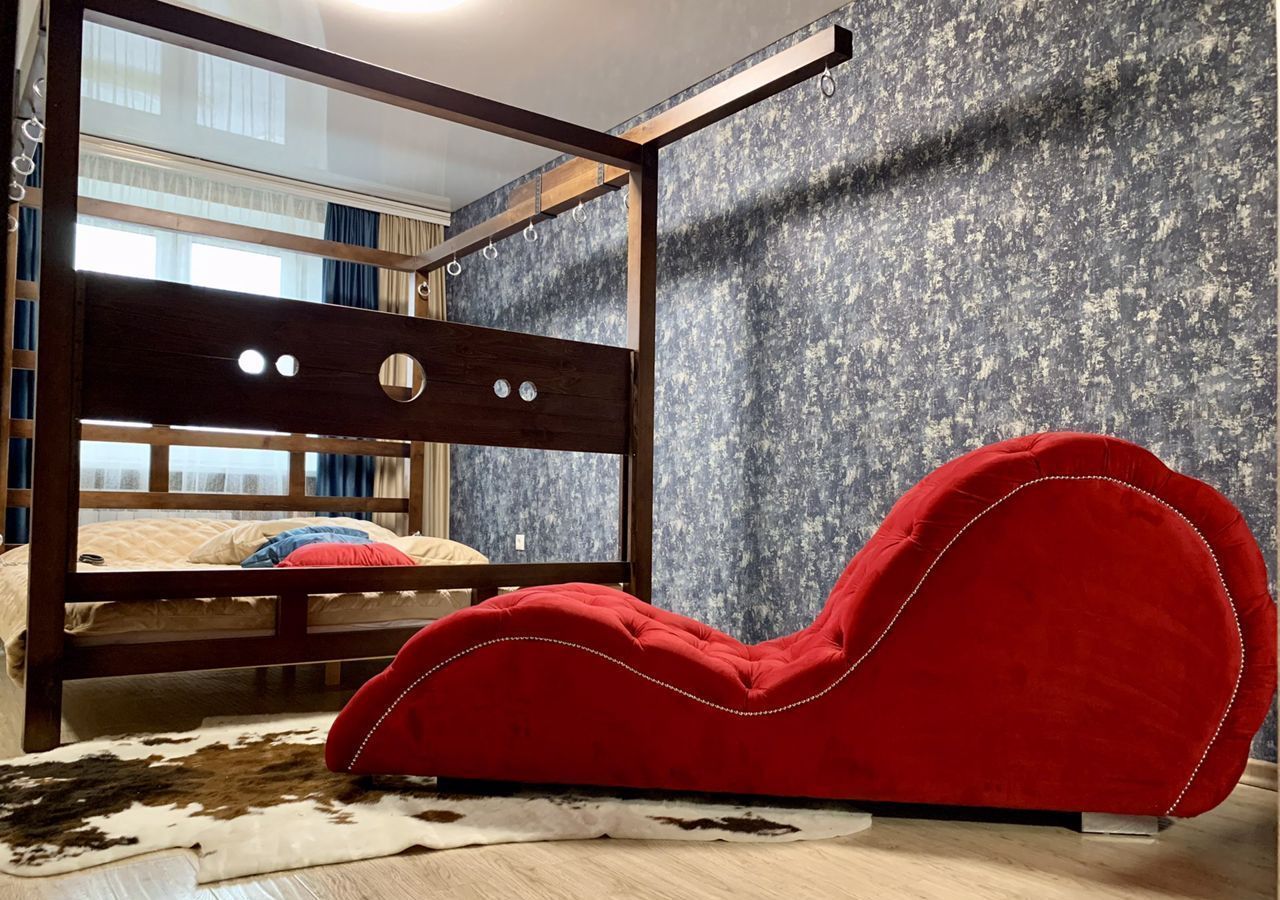 Для горячего вечера в комнате есть мягкая кровать и красный бархатный диван