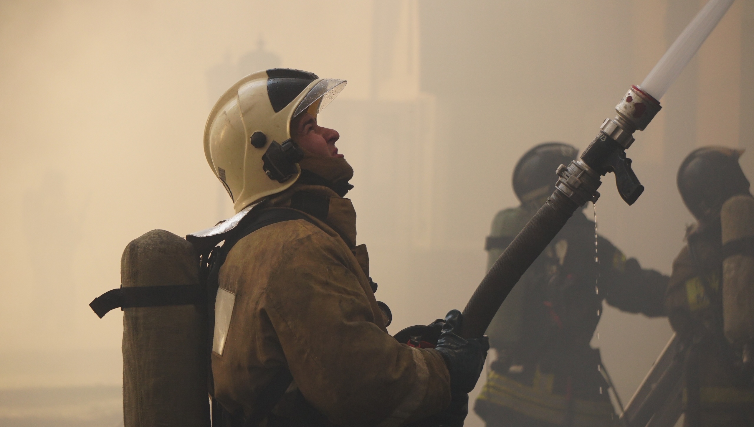 Около горящего здания было много спецмашин, пожарные рукава