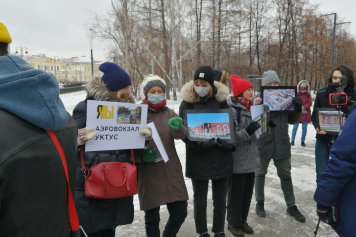 Собравшиеся держат в руках снимки снесенных зданий Собравшиеся держат в руках снимки снесенных зданий