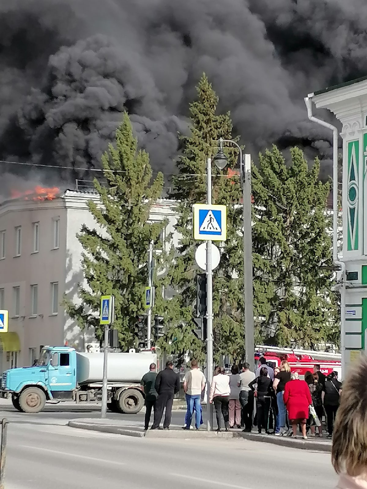 Люди собрались возле горящего здания Люди собрались возле горящего здания