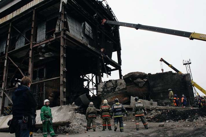 Спасатели на фоне обломков зданий предприятия