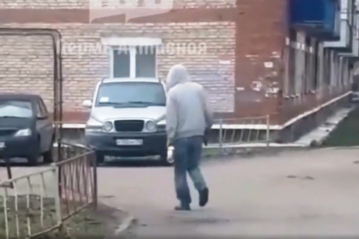 Мужчина, с трудом соблюдая равновесие, шел по улице с бутылкой и пистолетом в руках