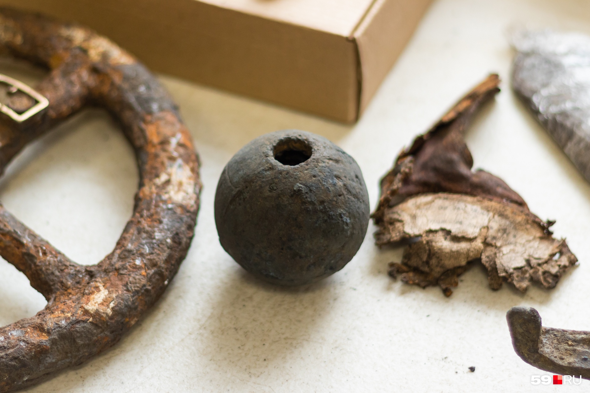 Круглый предмет — ручная граната, рядом часть кожаного предмета с надписью на идише