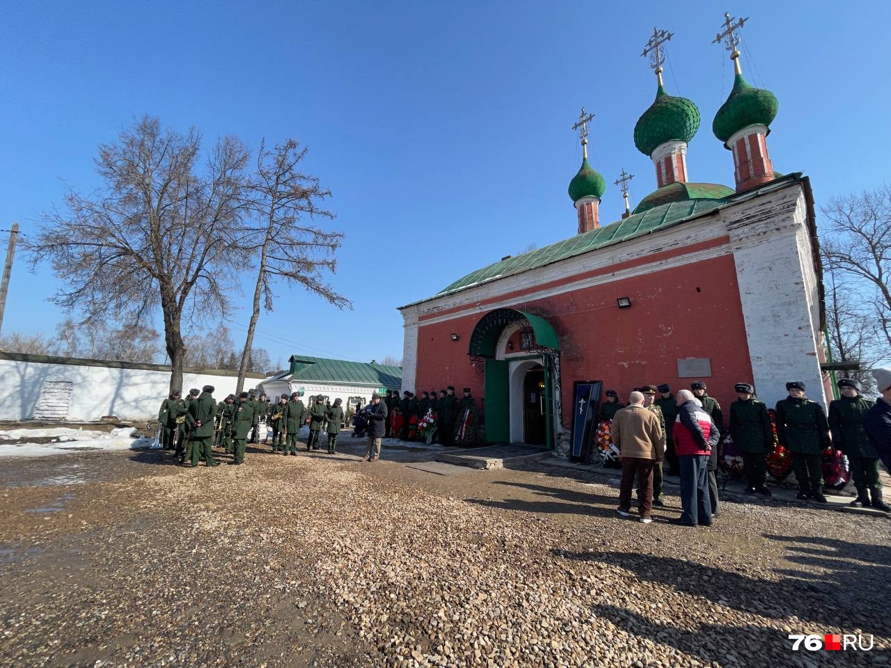 За стоящими у стены венками следили молодые парни в форме За стоящими у стены венками следили молодые парни в форме