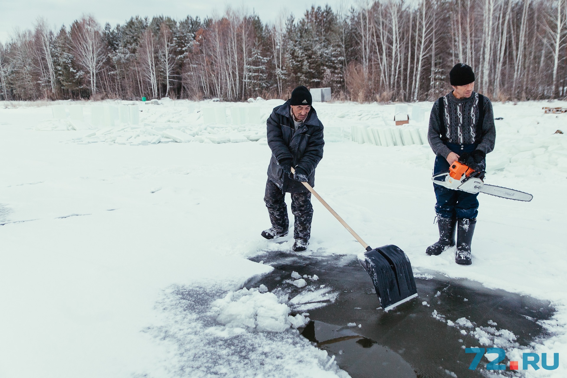 С помощью лопат мужчины расчищают площадку для добычи льда