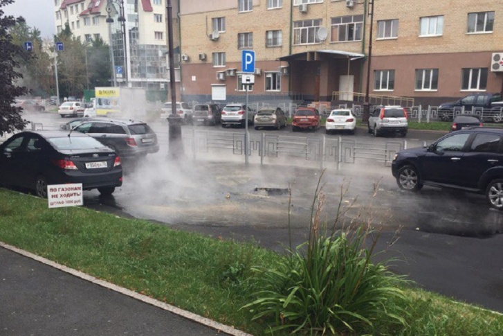 Вода выливается из провала в асфальте диаметром около полуметра Вода выливается из провала в асфальте диаметром около полуметра