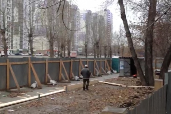 Двое рабочих собирают на площадке коробку под заливку фундамента Двое рабочих собирают на площадке коробку под заливку фундамента