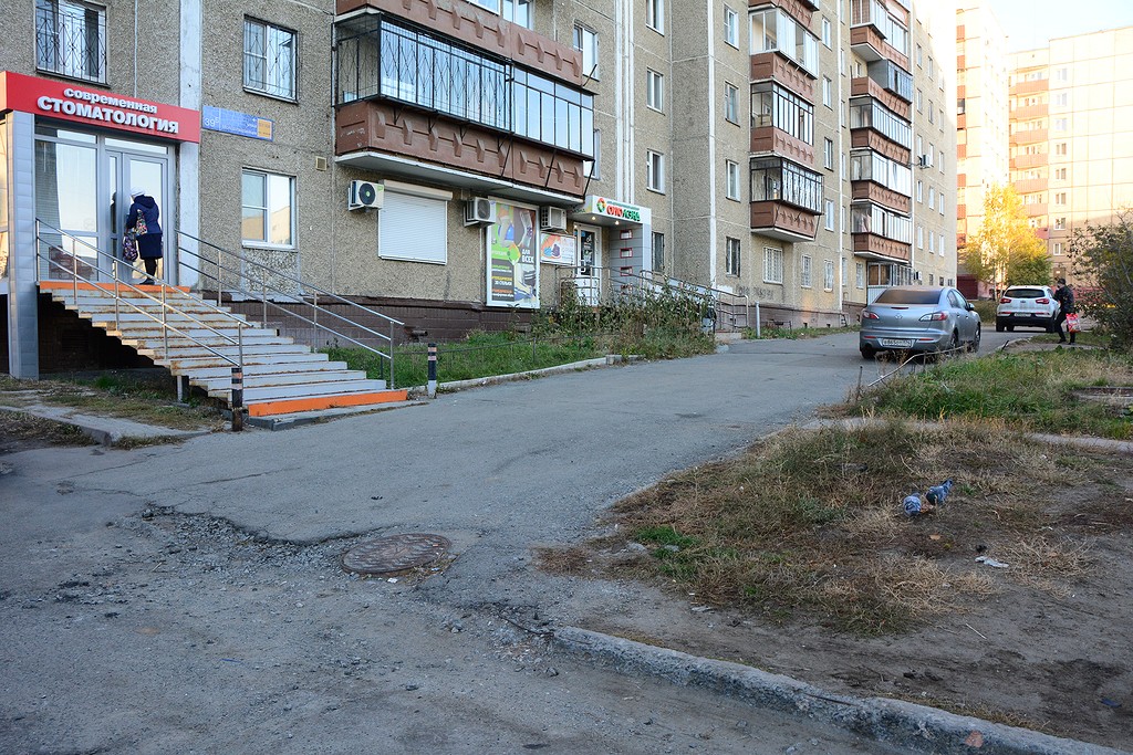 Один из домов по улице Молодогвардейцев: здесь сложно понять, является ли асфальт позади дома парковкой или тротуаром Один из домов по улице Молодогвардейцев: здесь сложно понять, является ли асфальт позади дома парковкой или тротуаром