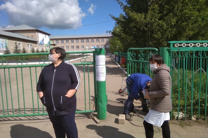 Две медсестры стоят у ворот больницы Две медсестры стоят у ворот больницы