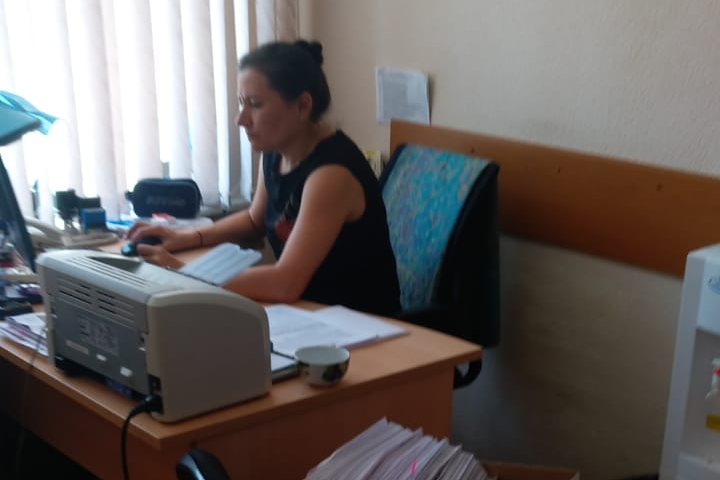 Маска у сотрудницы администрации есть. Она висит на лампе. А должна закрывать рот и нос женщины Маска у сотрудницы администрации есть. Она висит на лампе. А должна закрывать рот и нос женщины