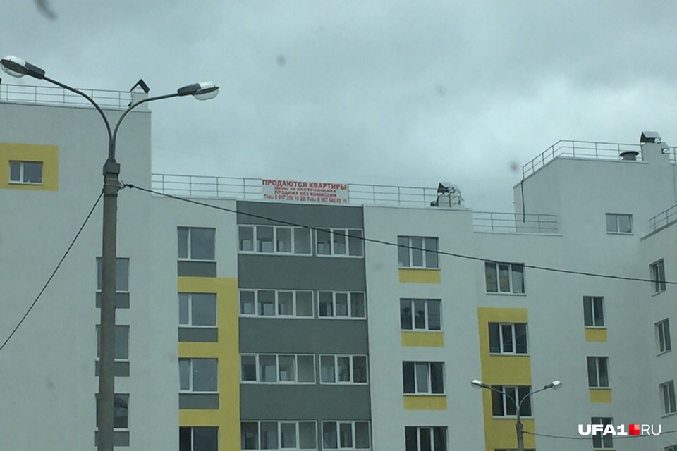На крыше одно из домов висит вывеска о продаже квартир в этих домах На крыше одно из домов висит вывеска о продаже квартир в этих домах