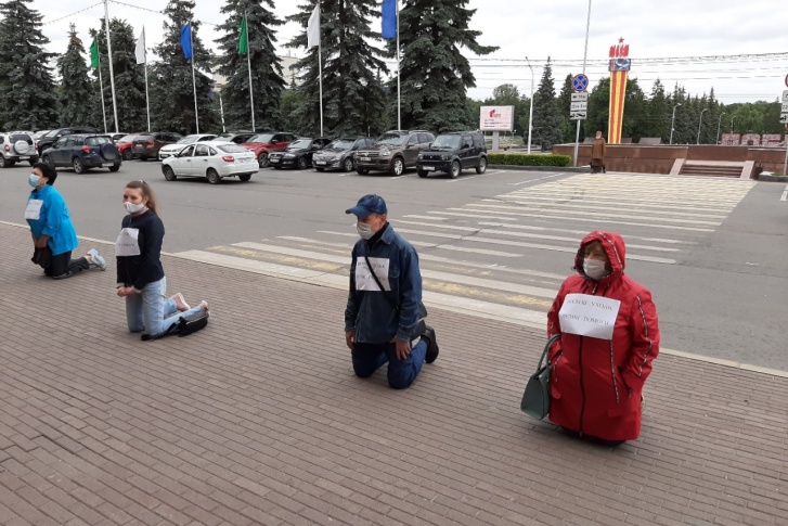 Люди встали в ряд перед зданием городской администрации Люди встали в ряд перед зданием городской администрации