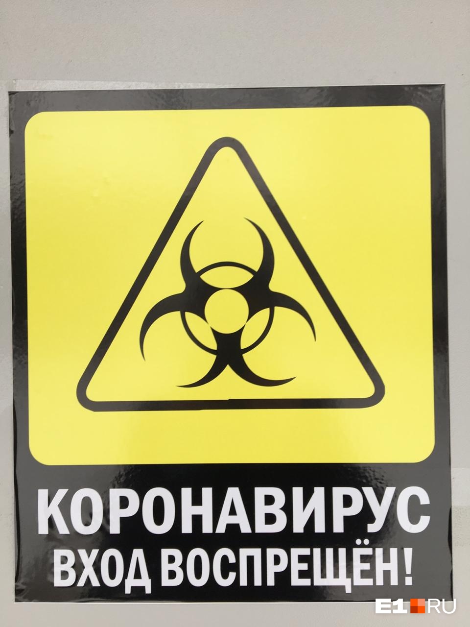 Табличка на входе предупреждает: здесь можно встретить коронавирус Табличка на входе предупреждает: здесь можно встретить коронавирус