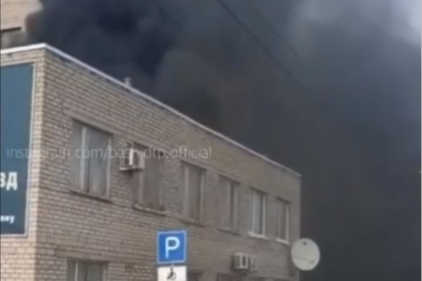 Видно, как здание охватывает черный дым Видно, как здание охватывает черный дым