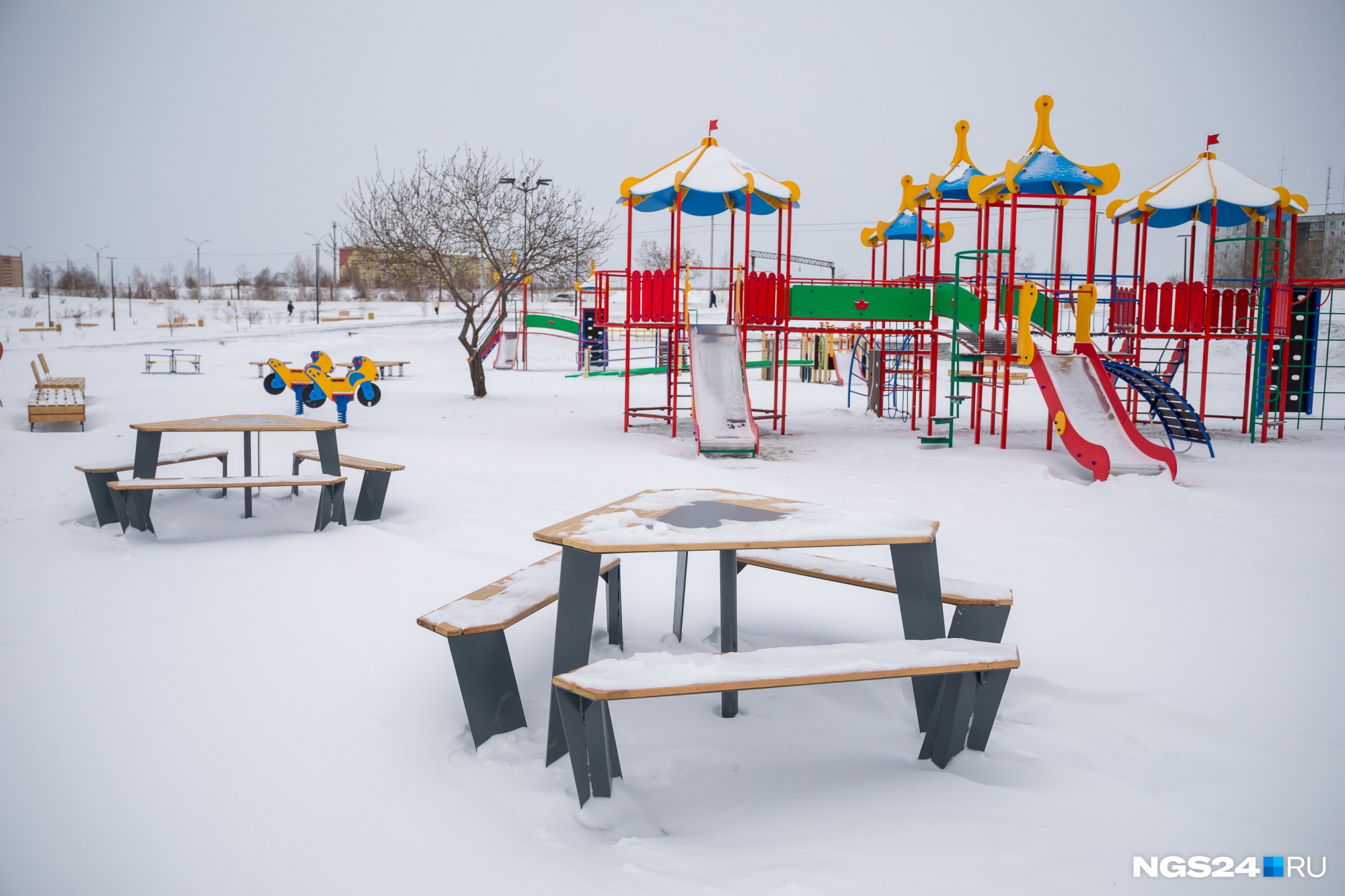 На детских площадках есть стильные столики для отдыха родителей. Но вот вместо наиболее безопасного прорезиненного покрытия на площадке насыпали щебень с песком