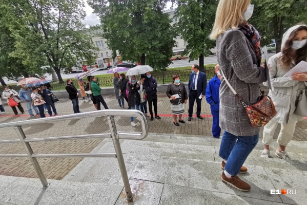 Люди стоят под дождем Люди стоят под дождем