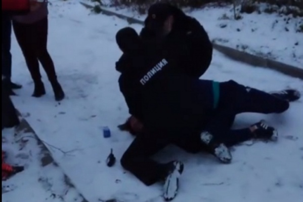 Двое полицейских повалили мужчину на снег Двое полицейских повалили мужчину на снег