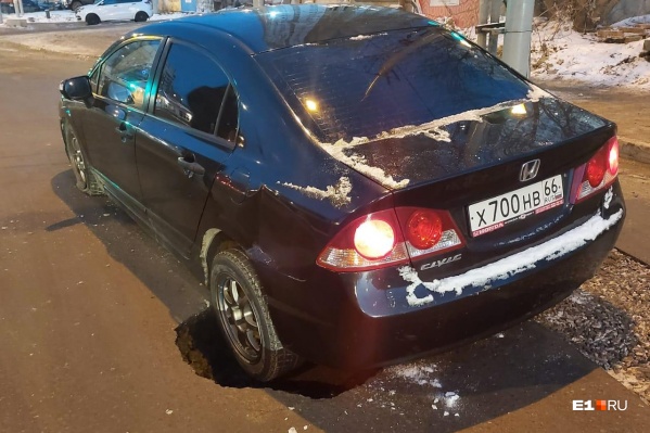 Машина задним колесом застряла в яме Машина задним колесом застряла в яме