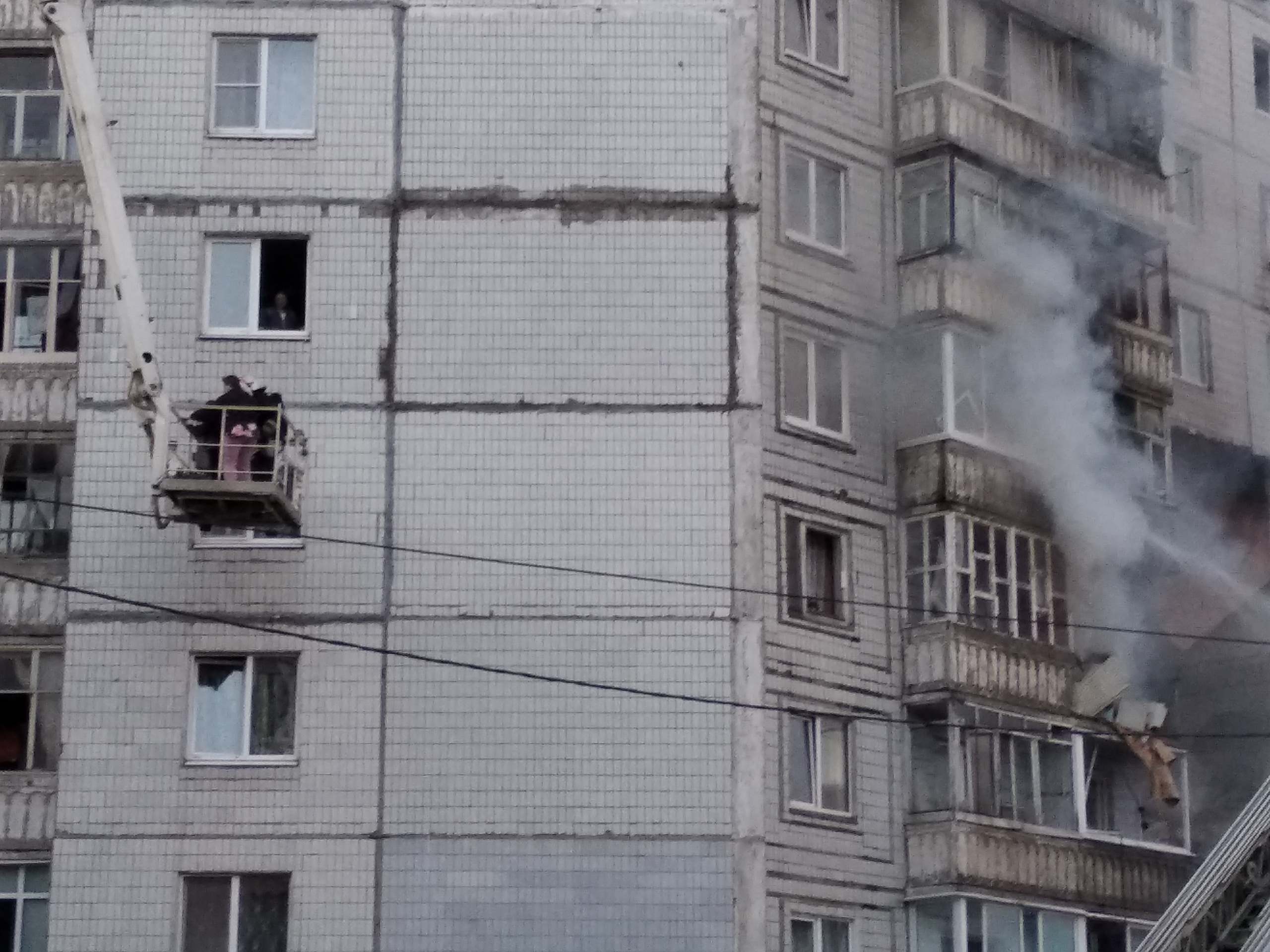 Спасатель спускается с людьми в люльке подъемника Спасатель спускается с людьми в люльке подъемника