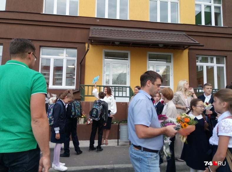 Возле школы уже толпа учеников, родителей и педагогов, но в масках лишь единицы из них Возле школы уже толпа учеников, родителей и педагогов, но в масках лишь единицы из них