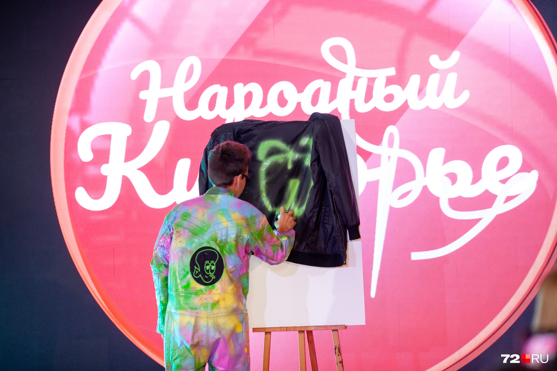 Это юный дизайнер Даниил Плесневцов, и он устроил на сцене настоящий перформанс — вынес холст и баллончик с краской. Ну вы видите