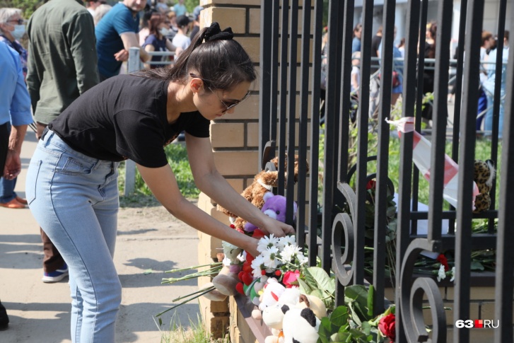 К школе, где погибли и пострадали дети, продолжают нести цветы и игрушки