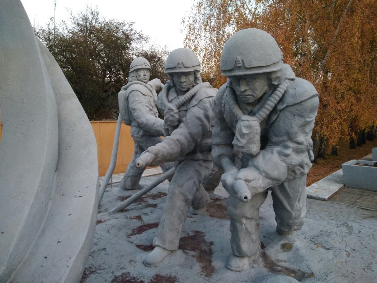 Памятник пожарным с надписью «Тем, кто спасал мир»