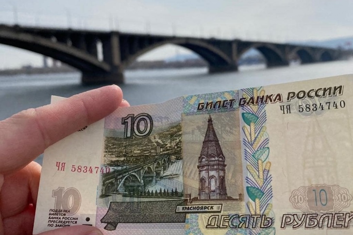 С купюрой делали фото на фоне моста и часовни в Красноярске