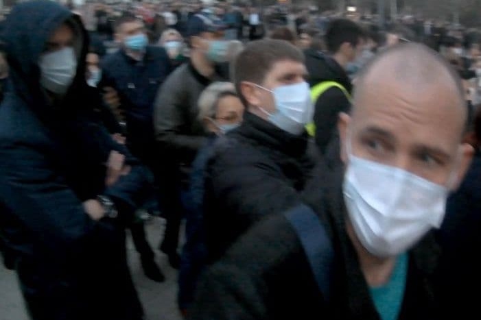 Олега Орлова (справа крупным планом) засняли на площади перед администрацией края в толпе протестующих
