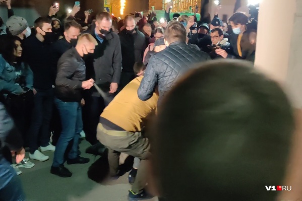 Полицейский в штатском старательно поливает газом лежащих на асфальте задержанных Полицейский в штатском старательно поливает газом лежащих на асфальте задержанных