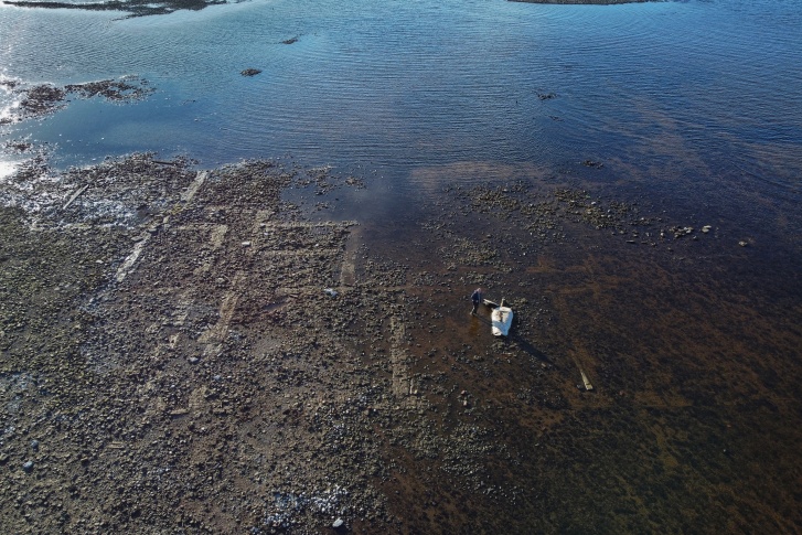 На показавшихся островках суши можно рассмотреть дорожки и остатки фундамента