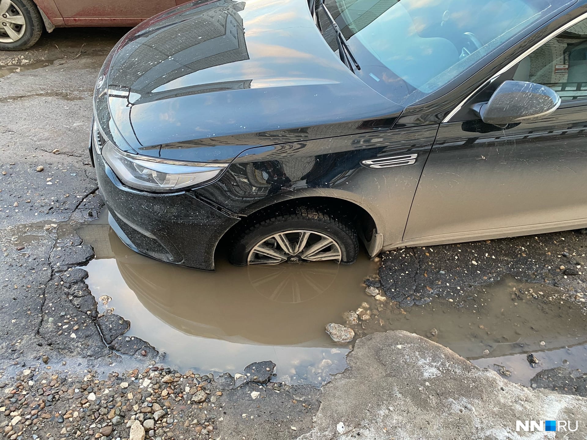 Колесо попало в яму на дороге. Яма для машины.