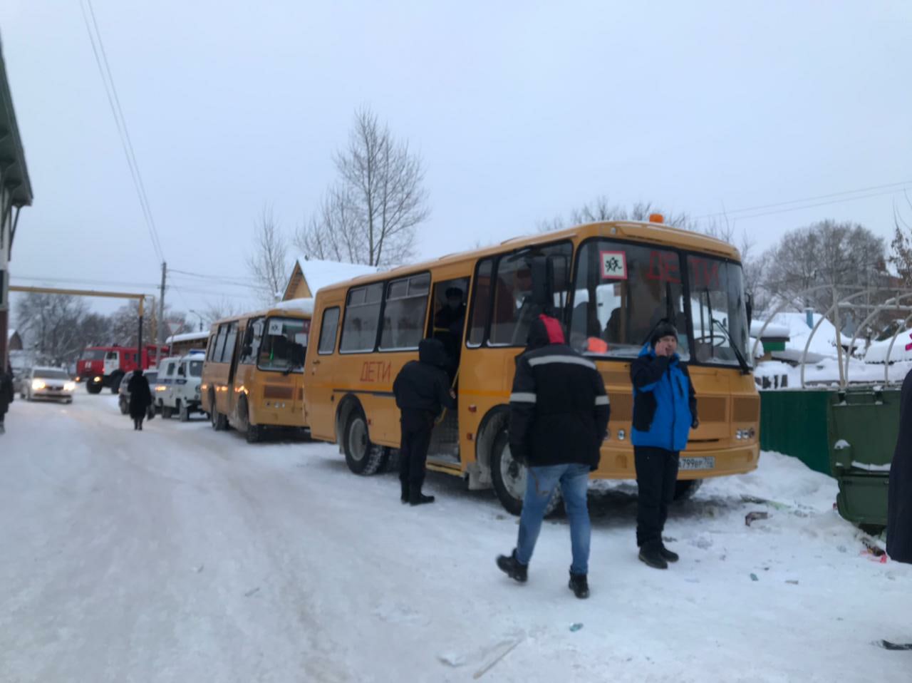 Эвакуированные жильцы дома греются в автобусах 