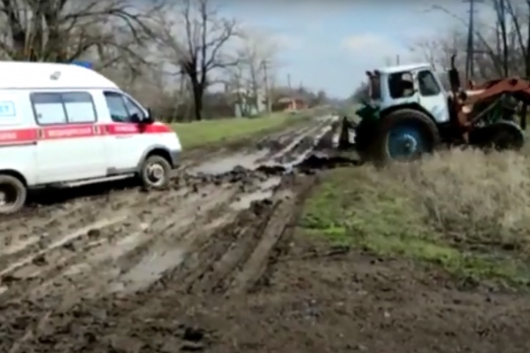 Машину выволакивали из грязи с помощью трактора Машину выволакивали из грязи с помощью трактора