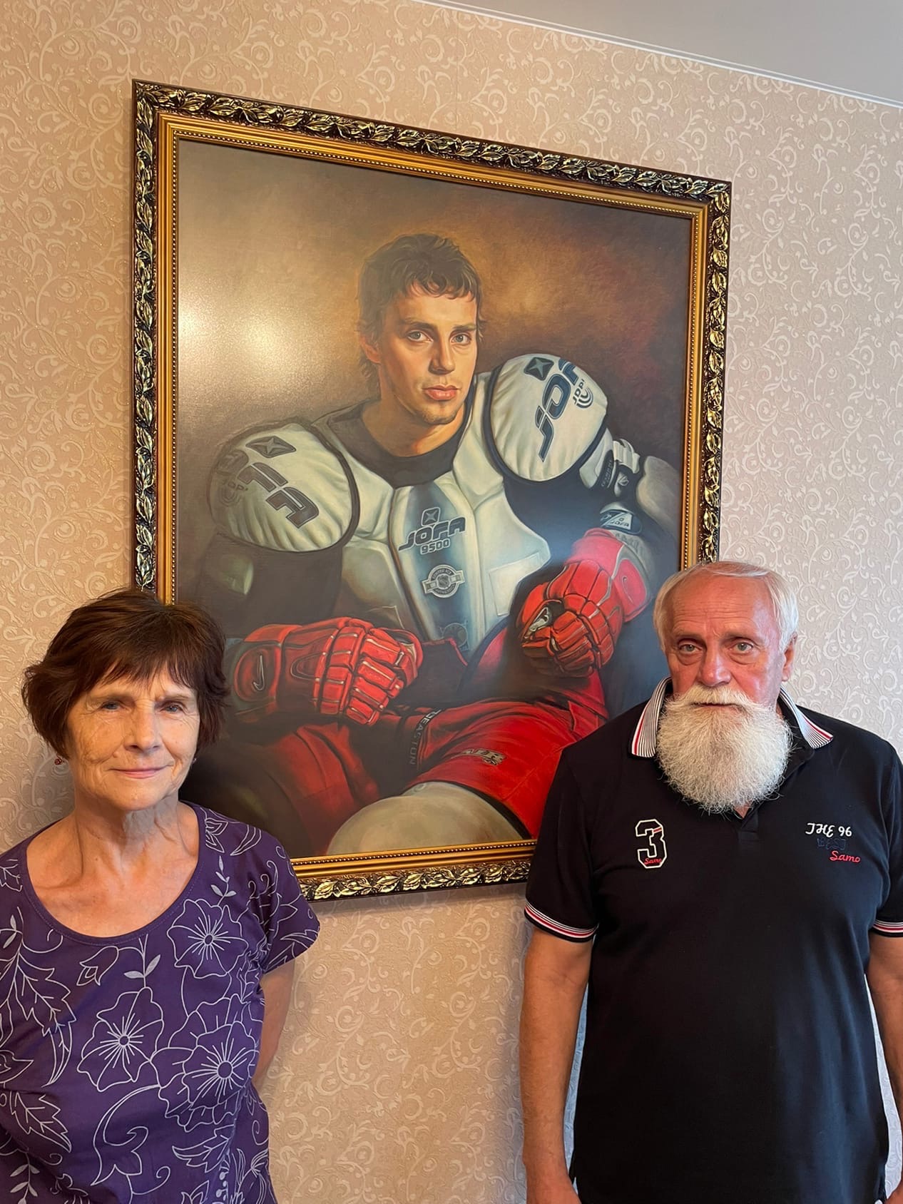 Родители Ивана Ткаченко рядом с портретом сына