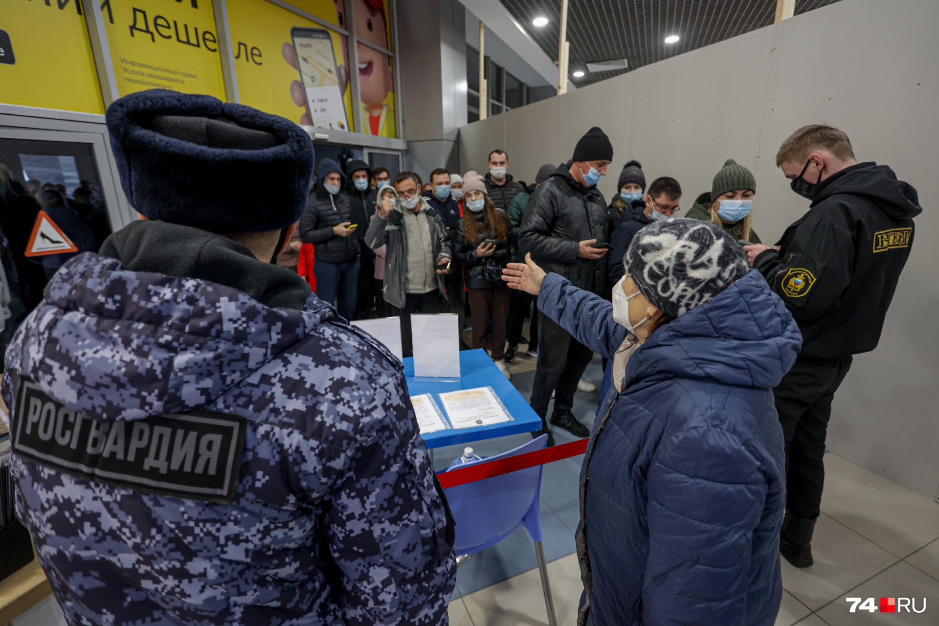 Женщина объясняет толпе, что на другом входе, внизу, нет очереди... Женщина объясняет толпе, что на другом входе, внизу, нет очереди...