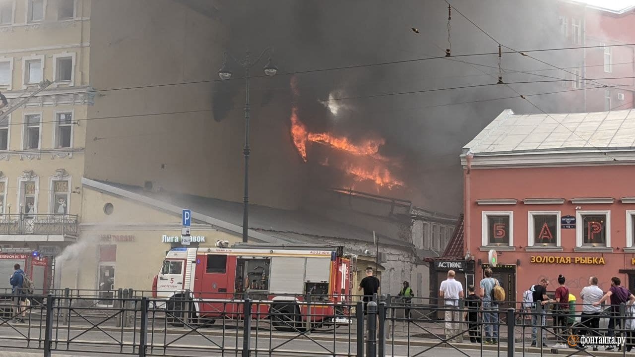 Лиговский проспект затянуло чёрным дымом, из окна дома вырывается пламя. Пожар тушат по повышенному номеру сложности