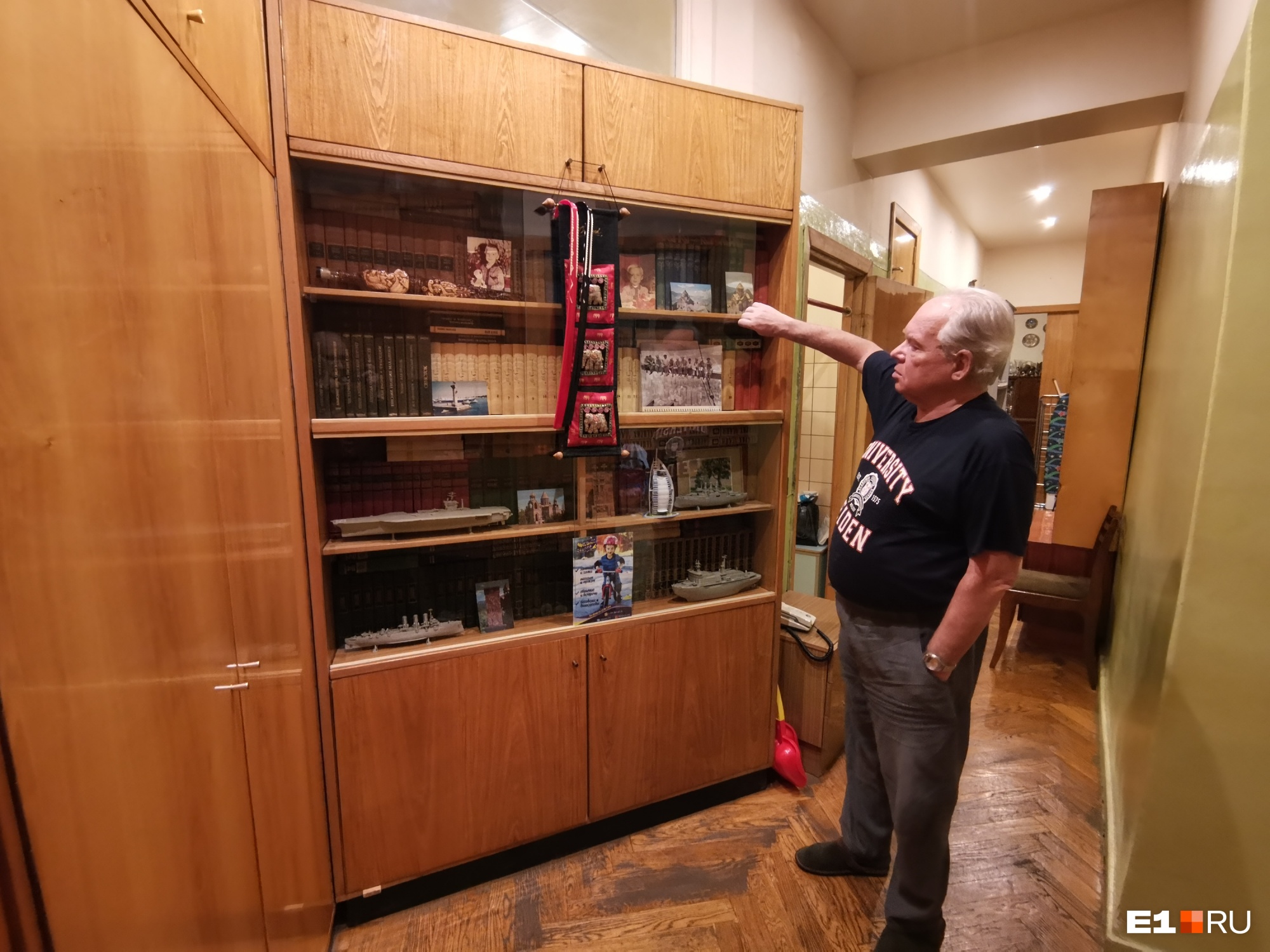Михаил Садовский показывает книжный шкаф в коридоре, оставшийся со времен, когда в квартире жили Ельцины