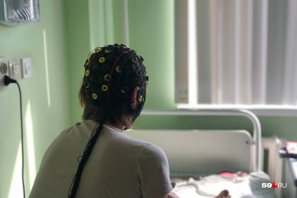 Пациентов с эпилепсией диагностируют с помощью специального оборудования. На женщине надет чепчик с электродами Пациентов с эпилепсией диагностируют с помощью специального оборудования. На женщине надет чепчик с электродами