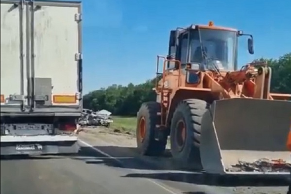 Всё, что осталось от иномарки, собирают в ковш трактора Всё, что осталось от иномарки, собирают в ковш трактора