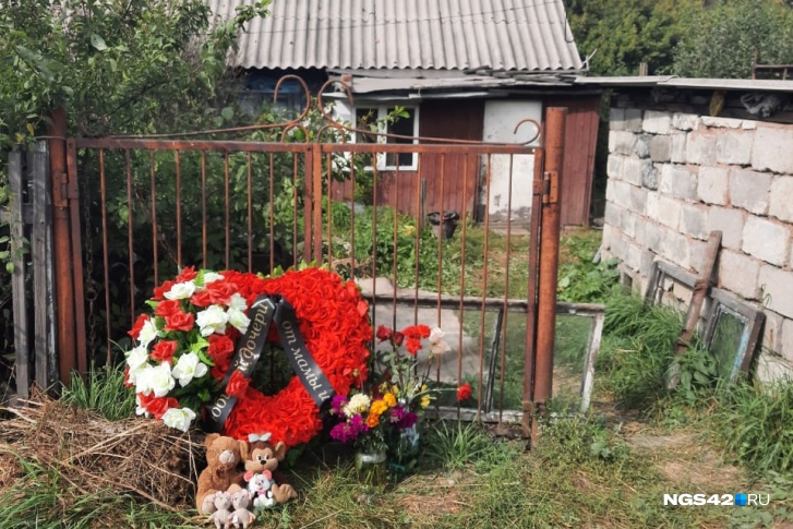 К дому, где убили девочек, несут цветы и игрушки К дому, где убили девочек, несут цветы и игрушки