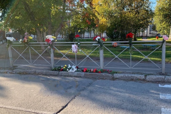 Люди приносят к месту гибели юноши цветы Люди приносят к месту гибели юноши цветы